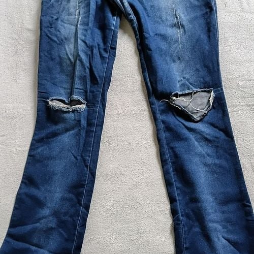 calça jeans flare azul com rasgos